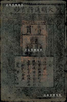 洪武年大明宝钞壹贯，中期版，票上名称字体笔画有力，章印较为明晰，其特别之处在于洪武年份左侧书有“弟子何宽福”字样，乃属昔年佛教信徒施舍给寺庙作为供奉佛像之历史实证，尤为值得珍视和推重；源于资深藏家出品，品相完整，七五成新