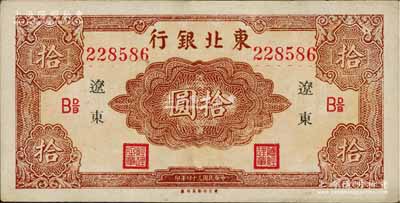 民国三十四年（1945年）东北银行红色拾圆长号券，辽东地名，下边有“东方印刷局印制”厂铭，且票内有英文水印，九至九五成新